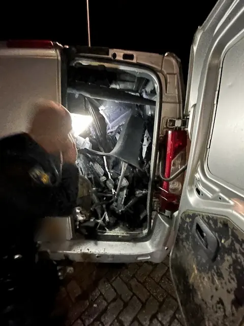 Furgons ar izjaukta auto detaļām, ko naktī pārbauda policists