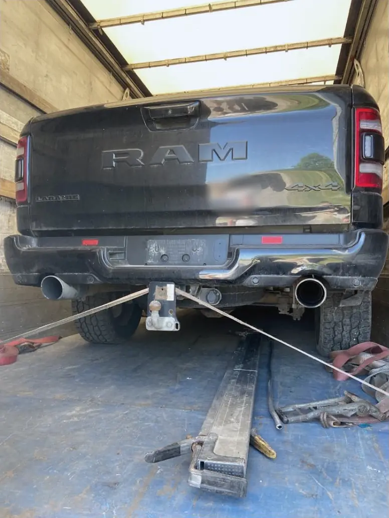 Melns RAM pikaps, ar siksnām piestiprināts kravas auto kravas telpā