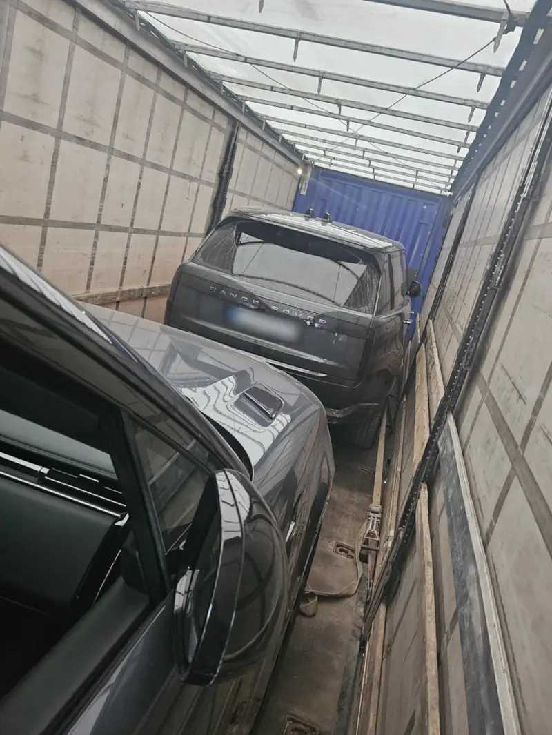 Zagti Range Rover kravas auto piekabē, numura zīme aizklāta